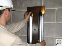 Mounting a foundation wall plate for an earth anchor installation in Cody.
