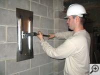 Attempting to straighten a bowed foundation wall by straightening a wall anchor system in a Riverton home.
