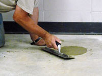 Repairing the cored holes in the concrete slab floor with fresh concrete and cleaning up the Riverton home.