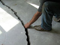 a severely damaged cracked concrete slab floor in Mills