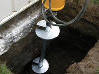 Installing a helical pier system in the earth around a foundation in Laramie