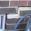 A closeup of a failed tuckpointing job where the brick cracked on a Edgerton home.