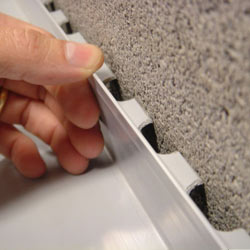 A contractor in Lander installing a perimeter drain tile system during a sump pump installation.