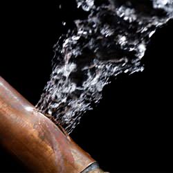 A bursting copper pipe in Laramie, with water gushing out.