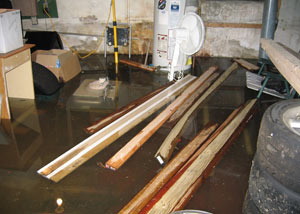 A severely flooding basement in Riverton, with lumber and personal items floating in a foot of water