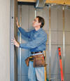 Insulated basement wall panels being placed against a concrete foundation wall in Evanston